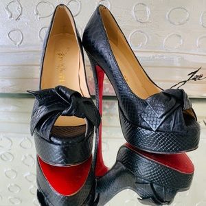 Black snakeskin pumps with red bottoms